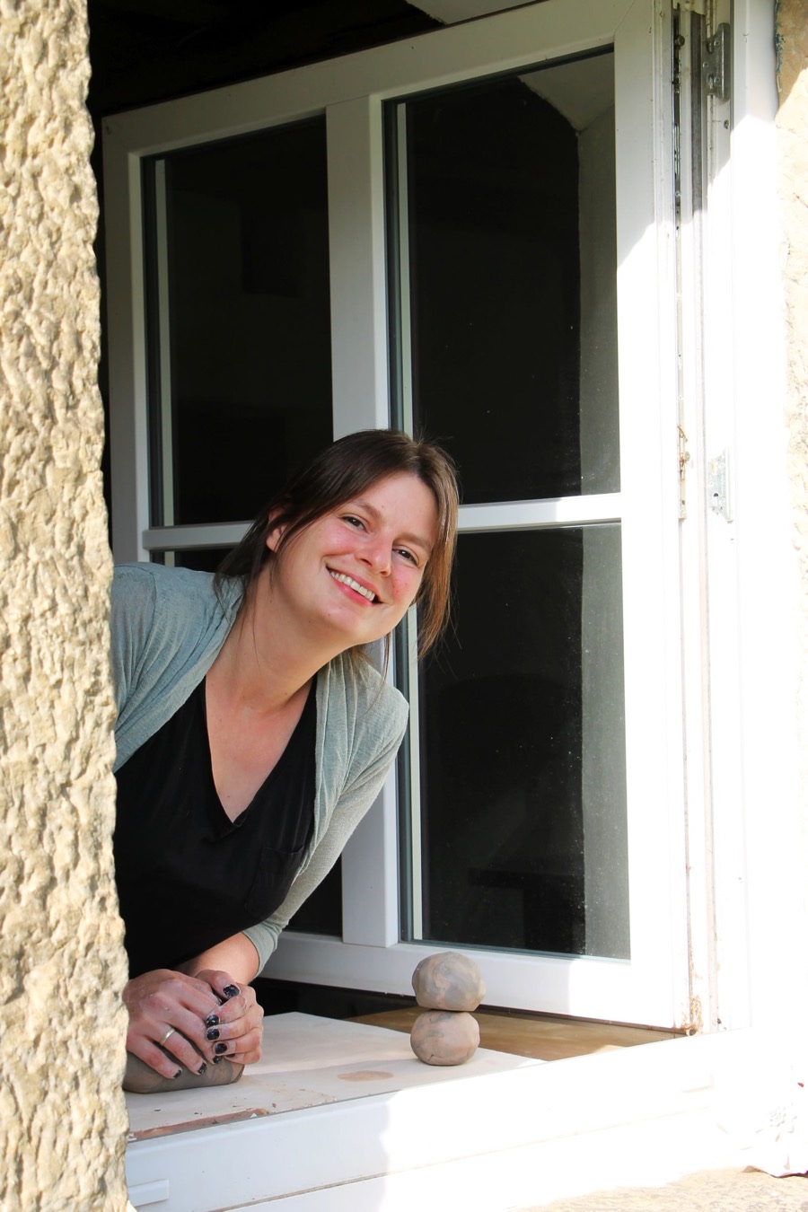 Franziska lehnt lächelnd aus einem Fenster des Guts